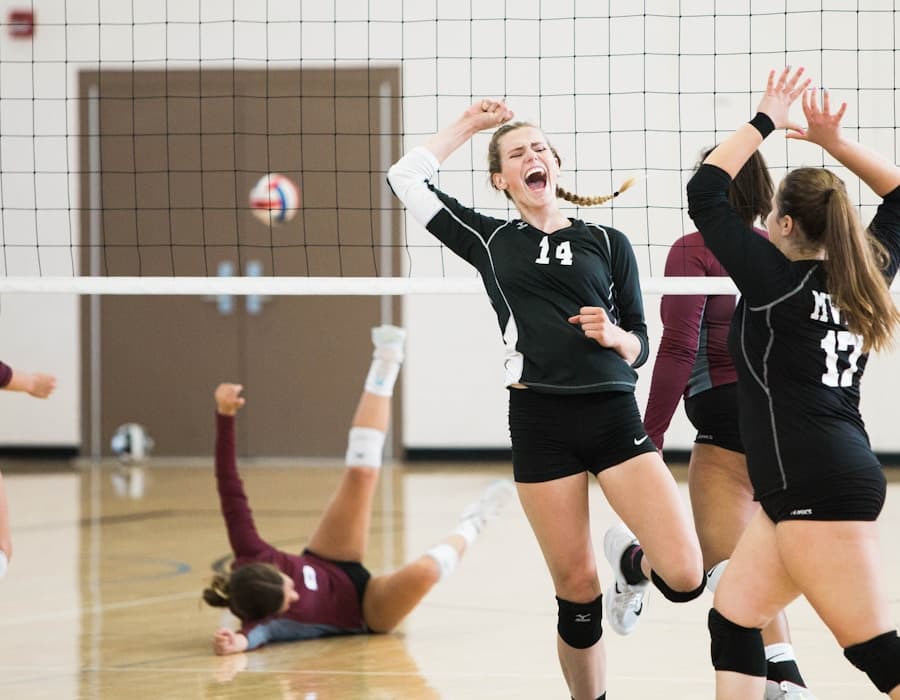Volleyball players training on an indoor court