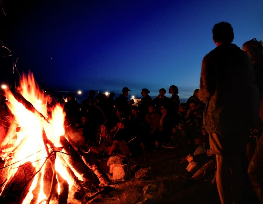 Friends gathered around a campfire at night