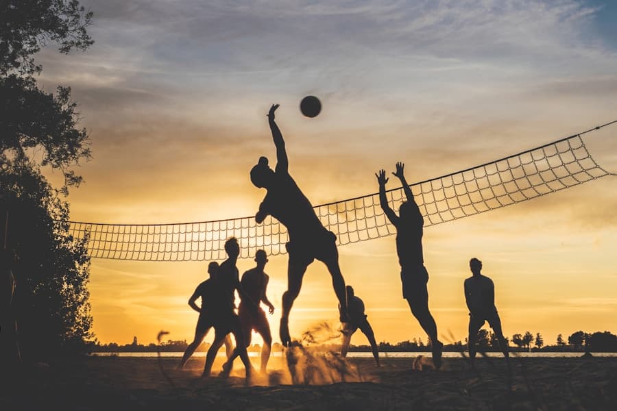 Silhouettes playing beach volleyball at sunset