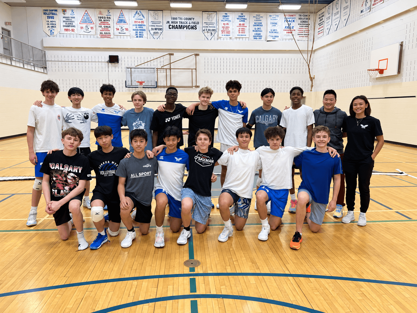 Youth volleyball team gathered on an indoor court
