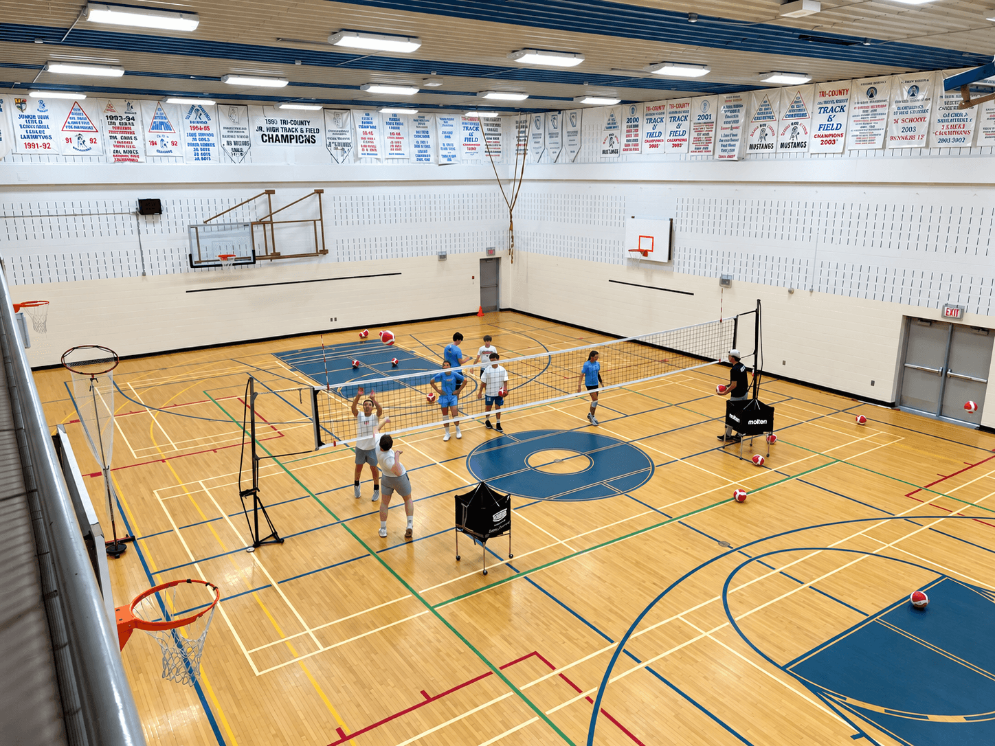 Athletes playing volleyball during an indoor training session